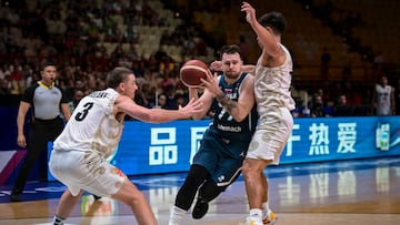 Slovenia�s Luka Doncic (C) fights for the ball with New Zealand�s Finn Delany (L) during the 2024 FIBA Olympic Qualifying Tournament basketball match between New Zealand and Slovenia at the Peace and Friendship Stadium in Athens on July 4, 2024. (Photo by Aris MESSINIS / AFP)