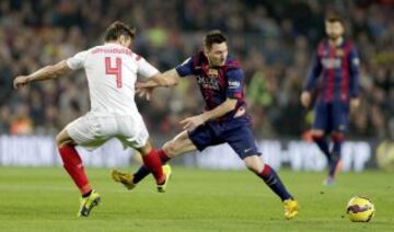 El delantero argentino del Barcelona Lionel Andrés Messi y el centrocampista del Sevilla Grzegorz Krychowiak luchan por el balón durante el partido correspondiente a la duodécima jornada de Liga que disputan en el estadio Camp Nou de Barcelona.