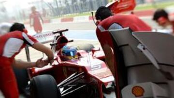 Los mecánicos de Ferrari trabajan en el monoplaza de Alonso durante la primera jornada de entrenamientos en la India.