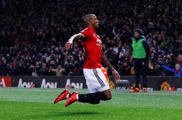 Manchester United's Ashley Young sets off on a knee-slide celebration after his shot was deflected in.