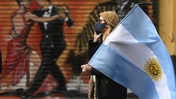 (FILES) In this file photo taken on July 9, 2020 a woman holds an Argentine flag during a protest against Argentina's President Alberto Fernandez health policies within the tighten virus lockdown measures against the spread of the novel COVID-19 coronavirus, at Republica Square in Buenos Aires. - Argentina has registered more than 100,000 COVID-19 cases, its Ministry of Health said on July 12, 2020, despite the Buenos Aires area -- the country's coronavirus hot spot -- being under extended shutdown. The country now has recorded 1,845 deaths from the pandemic with 100,153 positive cases and almost 43,000 people recovered. (Photo by Juan MABROMATA / AFP)