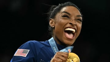 US' Simone Biles poses with the gold medal during the podium ceremony for the artistic gymnastics women's team final during the Paris 2024 Olympic Games at the Bercy Arena in Paris, on July 30, 2024. (Photo by Lionel BONAVENTURE / AFP)