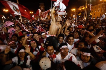 Supporters of Peru celebrate a goal against New Zealand during the 2018 World Cup qualifying play-off second leg football match, at the Plaza Mayor square in Lima, Peru, on November 15, 2017. / AFP PHOTO / STR