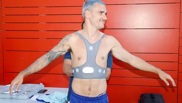 Un trabajador del club le coloca a Griezmann el aparato en el pecho.