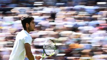 Carlos Alcaraz le devuelve la bola a Alexandre Muller en Wimbledon.