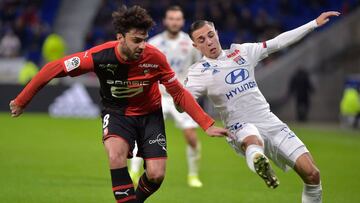 Lyon's French midfielder Maxence Caqueret (R) fights for the ball with Rennesx92 French midfielder Clement Grenier (L) during the French L1 football match between Olympique Lyonnais and Stade Rennais Football Club at the Groupama stadium in Decines-C
