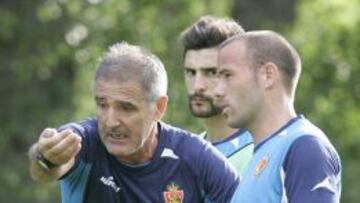 Paco Herrera da instrucciones a sus jugadores junto en presencia de Apoño.