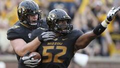 El jugador de f&uacute;tbol americano de la Universidad de Mossouri Michael Sam es felicitado por su compa&ntilde;ero Matt Hoch, durante un partido entre Missouri y el Sudeste de Louisiana en el campo Faurot Field en Columbia, Missouri. Michael Sam ha declarado p&uacute;blicamente ser gay.