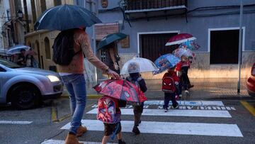 GRAFCVA9761. GANDÍA (VALENCIA), 22/10/2021.- Varias personas cruzan una calle bajo la lluvia cuando el litoral sur de Valencia y norte de Alicante está en preemergencia nivel naranja por lluvias durante hoy viernes y el fin de semana en la Comunitat Valenciana se presenta con lluvias durante el sábado, mientras que para el domingo el cielo estará poco nuboso y se espera un ligero aumento de las temperaturas máximas. EFE/ Natxo Francés