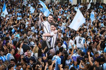 La fiesta por el título de campeones del mundo se recordará mucho tiempo mucho tiempo en toda Argentina. Un ejemplo de ello es esta imagen obtenida en Villa Urquiza, en Buenos Aires, donde un hincha sostiene una imagen gigante en cartón piedra de Lionel Messi y Julián Álvarez en medio de una enfervorizada multitud de aficionados de la Albiceleste.