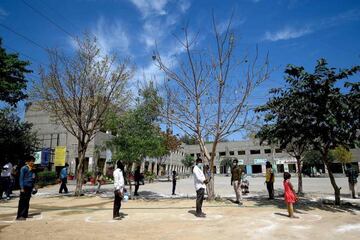 People queue to get free food at a government school during a government-imposed nationwide lockdown.