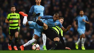 Fernandinho luchando por un balón con Martin Cranie del Huddersfield Town.