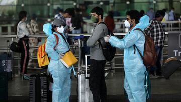 FILE PHOTO: Passengers wear personal protective equipment (PPE) as they stand in a queue to enter Chhatrapati Shivaji International Airport, after the government allowed domestic flight services to resume, during an extended nationwide lockdown to slow the spread of the coronavirus disease (COVID-19), in Mumbai, India, May 25, 2020. REUTERS/Francis Mascarenhas/File Photo