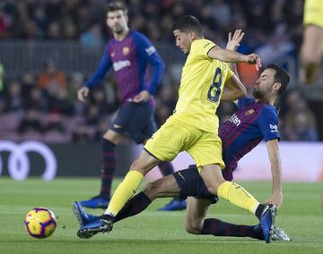 El jugador del Villarreal Fornals trata de controlar el balón ante el jugador del Barcelona Sergio Busquets. 
 