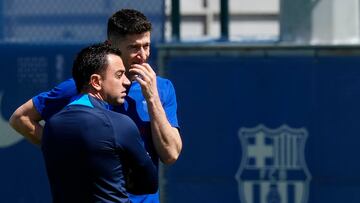 SANT JOAN DESPI ( BARCELONA ), 15/04/23 .- El delantero polaco del Barcelona , Robert Lewandowski , conversa con el entrenador , Xavi Hernandez (i) durante el entrenamiento del equipo este sabado de preparaci¨®n para el partido de LaLiga que les enfrenta ma?ana al Getafe . EFE/ Enric Fontcuberta.