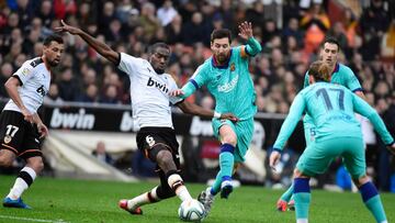TOPSHOT - Valencia&#039;s Central African Republic-French midfielder Geoffrey Kondogbia (L) challenges Barcelona&#039;s Argentine forward Lionel Messi (C) during the Spanish league football match Valencia CF against FC Barcelona at the Mestalla stadium in