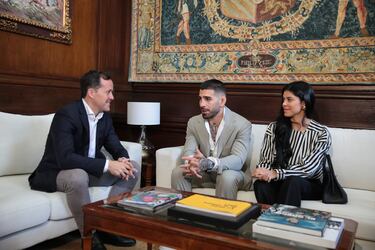 (I-D) El alcalde de Toledo, Carlos Velázquez; el actual campeón del mundo de peso pluma de la UFC, Ilia Topuria y su pareja Giorgina Uzcategui, durante una reunión en el Despacho de Alcaldía.