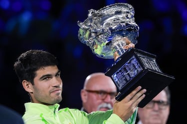 El español Carlos Alcaraz celebra con el trofeo tras ganar al serbio Novak Djokovic en su partido final individual masculino en el día quince del torneo de tenis Abierto de Australia en Melbourne