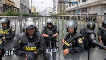 Police officers stand guard as supporters of Peruvian President Pedro Castillo gather outside the Congress headquarters in Lima on December 7, 2022. - Peru's President Pedro Castillo dissolved Congress on December 7, 2022, announced a curfew and said he will form an emergency government that will rule by decree, just hours before the legislature was due to debate a motion of impeachment against him. (Photo by Cris BOURONCLE / AFP) (Photo by CRIS BOURONCLE/AFP via Getty Images)