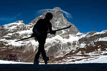 Un esquiador profesional camina por la estación de esquí de Breuil-Cervinia, al noroeste de Italia, con la imagen imponente y majestuosa del Matterhorn (Cervino), en Los Alpes, al fondo. Debido a la pandemia, las estaciones de esquí italianas parecen puertos desiertos, con tiendas, hoteles y restaurantes cerrados al público.