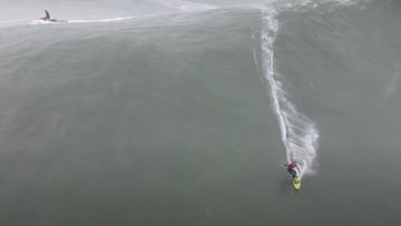 El surfista John Mel, con tabla de surf amarilla, neopreno y chalecho hinchable rojo, surfeando una de las olas gigantes de Mavericks, Half Moon Bay (California, Estados Unidos) el 10 de enero del 2021. En la esquina superior izquierda, un jet ski que le 