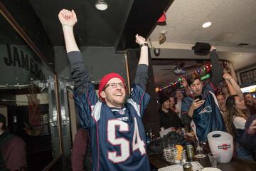 Los aficionados de los Patriots se reunieron en bares para ver el partido mientras comían alitas y bebían cervezas. En la imagen un seguidor celebra el final del partido.
