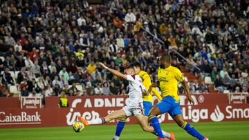 Dubasin, entre dos jugadores de la UD Las Palmas.
