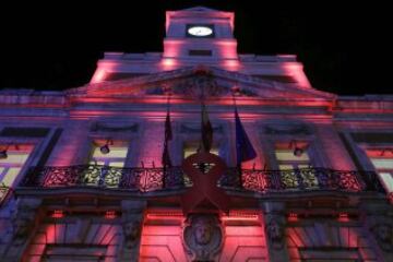 La sede de la Comunidad de Madrid, en la Puerta del Sol, iluminada de rojo por la celebración el 1 de diciembre del Día Mundial del Sida.