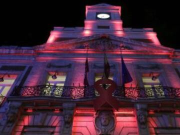 La sede de la Comunidad de Madrid, en la Puerta del Sol, iluminada de rojo por la celebración el 1 de diciembre del Día Mundial del Sida.