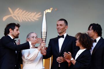 El atleta paralímpico Alexis Hanquinquant sostiene la llama olímpica durante el estreno de "Marcello Mio" en el festival de Cannes.