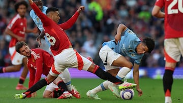 Manchester United's Brazilian midfielder #18 Casemiro (2L) vies with Manchester City's English defender #82 Rico Lewis (R) during the English Premier League football match between Manchester United and Manchester City at Old Trafford in Manchester, north west England, on April 6, 2025. (Photo by Darren Staples / AFP) / RESTRICTED TO EDITORIAL USE. No use with unauthorized audio, video, data, fixture lists, club/league logos or 'live' services. Online in-match use limited to 120 images. An additional 40 images may be used in extra time. No video emulation. Social media in-match use limited to 120 images. An additional 40 images may be used in extra time. No use in betting publications, games or single club/league/player publications. /