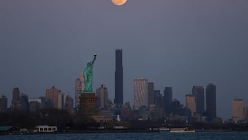 JERSEY CITY, NJ - MARCH 13: The full Worm Moon rises above the skyline of Brooklyn and the Statue of Liberty as the sun sets in New York City ahead of a total lunar eclipse on March 13, 2025, as seen from Jersey City, New Jersey. (Photo by Gary Hershorn/Getty Images)