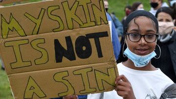 A protester holds a placard as they attend a demonstration in Edinburgh on June 7, 2020, organised to show solidarity with the Black Lives Matter movement in the wake of the killing of George Floyd, an unarmed black man who died after a police officer kne