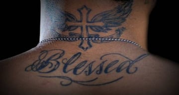 La cruz alada y la palabra "Blessed" que lleva Neymar tatuadas en su nuca y en la parte superior de su espalda.