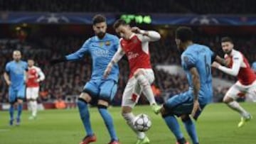 Gerard Piqu&eacute; trata de quitarle el bal&oacute;n a Mesut &Ouml;zil durante el partido de Champions League entre el Arsenal y el F.C. Barcelona.
