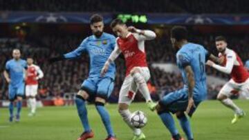 Gerard Piqué trata de quitarle el balón a Mesut Özil durante el partido de Champions League entre el Arsenal y el F.C. Barcelona.