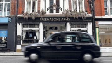 Un taxi londinense pasa por delante del hist&oacute;rico Freemasons Arms.