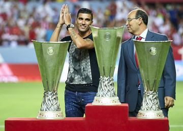 Despedida del S¨¢nchez Pizju¨¢n al jugador de Utrera tras su segunda etapa en el club. Posa junto al presidente y las tres Europa League conseguidas defendiendo la camiseta del club hispalense.