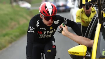 Team Visma-Lease a Bike's Danish rider Jonas Vingegaard (L) grabs an enegry gel from his team's car after falling during the 5th stage of the Paris-Nice cycling race, 196,5 km between Saint-Just-en-Chevalet and La C�te-Saint-Andr�, on March 13, 2025. (Photo by Anne-Christine POUJOULAT / AFP)