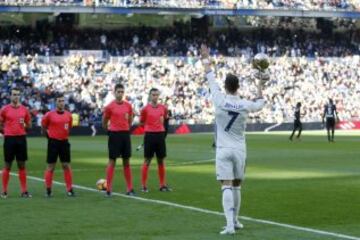 Cristiano ofrece a la grada del Santiago Bernabéu su cuarto galardón como mejor futbolista del mundo.