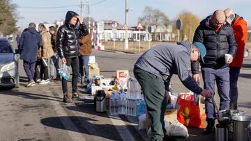 Volunteers hand out tea, water and food to people crossing the border from Ukraine into the Romanian town of Siret.