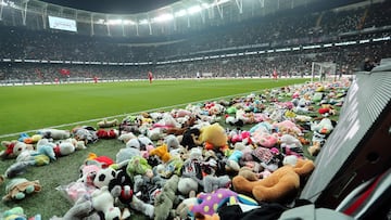 This handout photograph taken and released by Turkish agency DHA (Demiroren News Agency) on February 26, 2023 shows players collecting toys from the pitch as Besiktas fans throw toys onto the pitch during the Turkish Super League soccer match between Besiktas and Antalyaspor at the Vodafone stadium in Istanbul. - Besiktas supporters threw a massive number of soft toys to be donated to children affected by the powerful earthquake on Feb. 6 on southeast Turkey. (Photo by Handout / DHA (Demiroren News Agency) / AFP) / RESTRICTED TO EDITORIAL USE - MANDATORY CREDIT "AFP PHOTO / DHA (DEMIROREN NEWS AGENCY) " - NO MARKETING NO ADVERTISING CAMPAIGNS - DISTRIBUTED AS A SERVICE TO CLIENTS