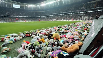 This handout photograph taken and released by Turkish agency DHA (Demiroren News Agency) on February 26, 2023 shows players collecting toys from the pitch as Besiktas fans throw toys onto the pitch during the Turkish Super League soccer match between Besiktas and Antalyaspor at the Vodafone stadium in Istanbul. - Besiktas supporters threw a massive number of soft toys to be donated to children affected by the powerful earthquake on Feb. 6 on southeast Turkey. (Photo by Handout / DHA (Demiroren News Agency) / AFP) / RESTRICTED TO EDITORIAL USE - MANDATORY CREDIT "AFP PHOTO / DHA (DEMIROREN NEWS AGENCY)  " - NO MARKETING NO ADVERTISING CAMPAIGNS - DISTRIBUTED AS A SERVICE TO CLIENTS