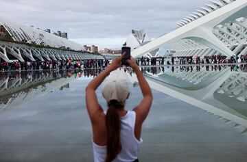 Una persona toma una fotografía mientras los voluntarios hacen fila para recibir instrucciones sobre cómo organizarse para brindar la mejor ayuda a los afectados por las inundaciones y las fuertes lluvias, en la Ciudad de las Artes y las Ciencias en Valencia.