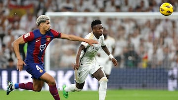 Barcelona's Uruguayan defender #04 Ronald Araujo and Real Madrid's Brazilian forward #07 Vinicius Junior vie for the ball during the Spanish league football match between Real Madrid CF and FC Barcelona at the Santiago Bernabeu stadium in Madrid on April 21, 2024. (Photo by OSCAR DEL POZO / AFP)