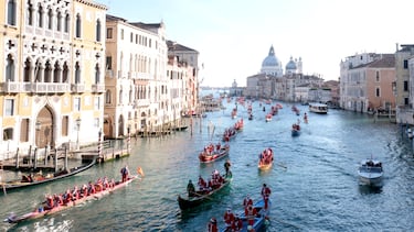 Personas vestidas de Papá Noel reman durantela  regata navideña en el Gran Canal de Venecia.
