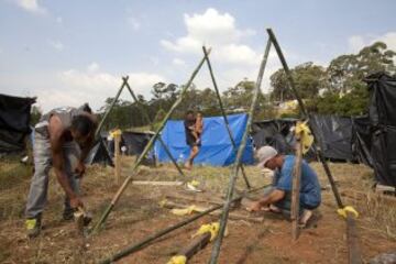 Integrantes del Movimiento de los Trabajadores Sin Techo (MTST) construyen viviendas improvisadas en una área que fue ocupada el pasado sábado situada a unos 4 kilómetros del estadio Arena Corinthians de Sao Paulo, una de las doce sedes del Mundial Brasil 2014 y que recibirá seis partidos del evento deportivo, entre ellos el inaugural del 12 de junio. De acuerdo con el movimiento, las familias que ocuparon el terreno, abandonado desde hace más de 20 años, vivían en áreas "de riesgo", "en favelas o sin condiciones para pagar el alquiler por culpa de la especulación inmobiliaria en la región, resultado de la construcción del estadio de apertura del Mundial".