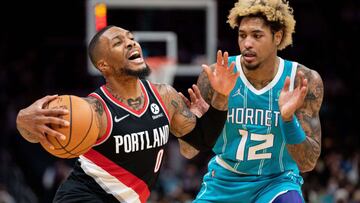 Damian Lillard trata de superar a Kelly Oubre Jr. durante el Charlotte Hornets-Portland Trail Blazers.