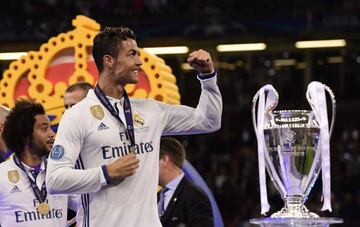Real Madrid's Portuguese striker Cristiano Ronaldo celebrates next to the trophy after Real Madrid won the UEFA Champions League final football match between Juventus and Real Madrid at The Principality Stadium in Cardiff, south Wales, on June 3, 2017