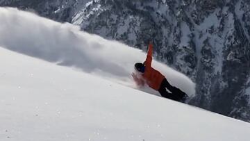David Vicente sacando spray con su tabla de snowboard.